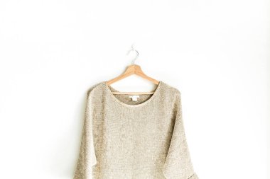 Beyaz arka plan üzerinde izole askı kazak üzerinde kadın kazak yakın çekim. Kadın moda giysiler kavramı