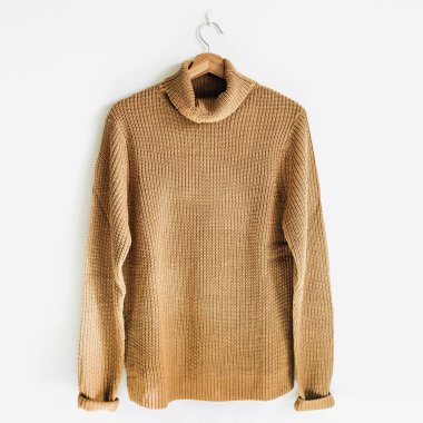 Kadınsı jumper, beyaz duvar askı üzerinde. Kadın moda giysiler kavramı.