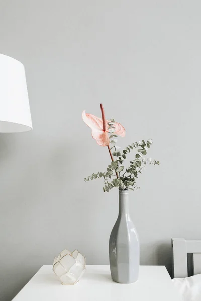 パステル カラーの壁 テーブルの上の瓶にピンクのアンスリウムの花とユーカリ ブランチ花の花束 最小限のモダンなトレンディなインテリア デザインのコンセプト — ストック写真