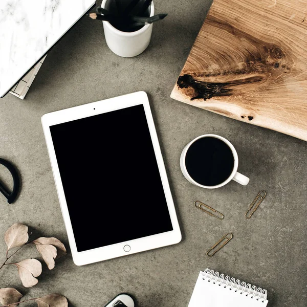 Flatlay tablet kopyalama alanı ekranı ile alay et. Okaliptüs, ahşap levha ve ileti örneği ile dekore edilmiş üstten görünüm ev ofis resepsiyon çalışma alanı.