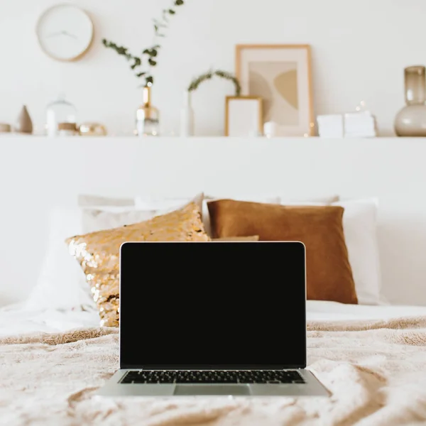 Relax, chill with laptop in bed with pillows. Apartment interior design concept. Freelancer, blogger composition. Blank mockup screen hero header for blog, website, social media.