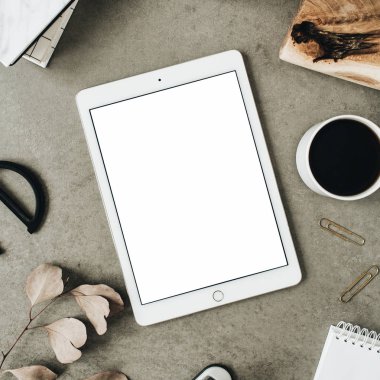 Flatlay tablet kopyalama alanı ekranı ile alay et. Okaliptüs, ahşap levha ve ileti örneği ile dekore edilmiş üstten görünüm ev ofis resepsiyon çalışma alanı.