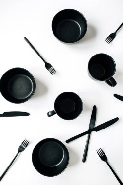 Siyah trendy mutfak eşyaları: çatal, bıçak, kupalar, kase beyaz arka plan üzerinde. Düz yatıyordu, en iyi görünümü modern mutfak en az konsepti.