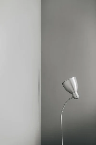 Silver floor lamp at grey wall. Minimal modern interior design concept.