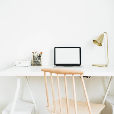 Ev ofis resepsiyon çalışma alanı. Boş ekran sahte kadar altın lamba, beyaz masaüstü ileti örneğine sahip dizüstü bilgisayarı. Modern İskandinav iç tasarım konsepti.