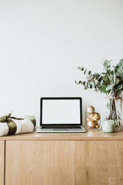 Blogger, serbest ev ofis resepsiyon çalışma alanı. Okaliptüs kokulu, hediye kutusu, beyaz zemin üzerine mumlar laptop sahte ahşap masaüstü ekranı ile dekore edilmiş.