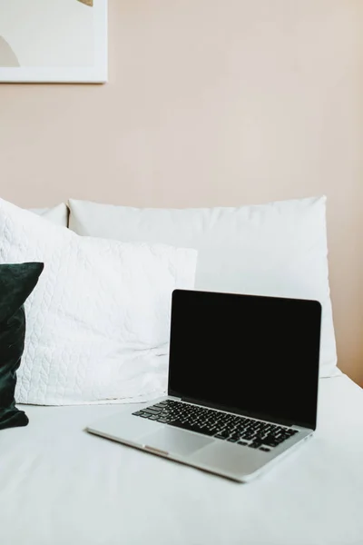 Laptop in bed with pillows. Freelancer / blogger / writer lifestyle concept. Work at home concept.