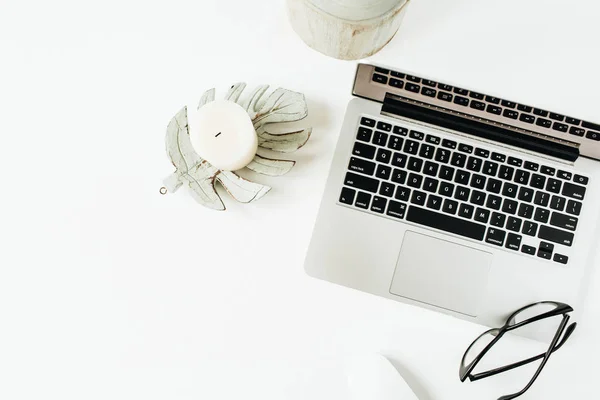 Minimal home office desk workspace with laptop, glasses on white background. Flat lay, top view lifestyle blog template.