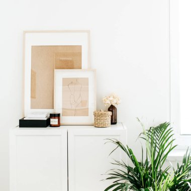 Modern minimal İskandinav İskandinav iç tasarım. Çekmecesandık, fotoğraf çerçeveleri, palmiye ev bitki ve dekor.