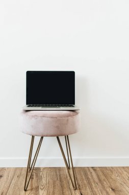 Beyaz arka plan üzerinde şık dışkı üzerinde boş mockup ekran dizüstü ön görünümü. Blog, web sitesi, sosyal medya kahraman başlık.