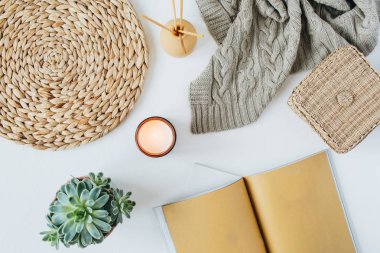 Dizüstü bilgisayar, sulu, örme ekose, mum, aroma çubukları, beyaz arka plan üzerinde saman hasır peçeteler ile Boho tarzı modern minimal ev çalışma alanı masası. Düz yatıyordu, üst görünümü bohem yaşam tarzı blog kahraman başlık.
