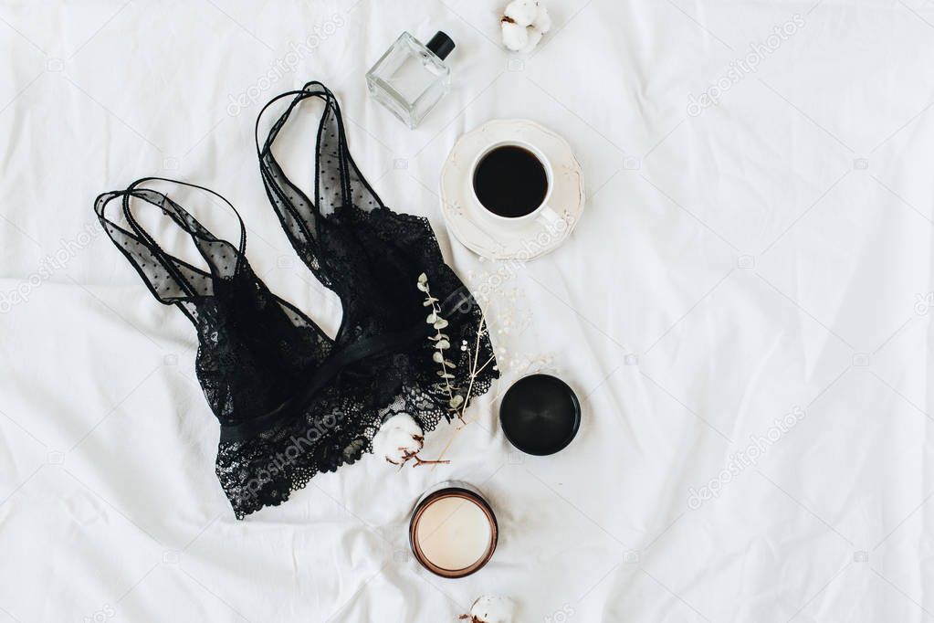 Fashion trendy women's underwear composition. Bra, perfume, coffee, cotton on white linen. Flat lay, top view beauty blog minimal concept.