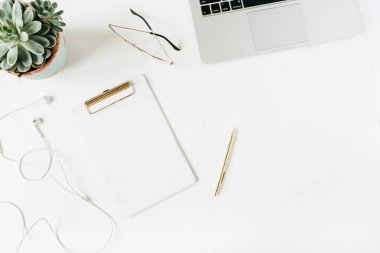 Boş kopya alan panosu, dizüstü bilgisayar, kulaklık, gözlük, beyaz arka plan üzerinde sulu ile Home ofis masası çalışma alanı. Düz yatıyordu, üst görünüm modern minimalist blog kahraman başlık.