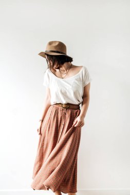 Şapkalı, bluzlu, beyaz arka planda etekli güzel bir kadın. Moda modasına uygun kıyafetler. Yaşam tarzı kavramı.