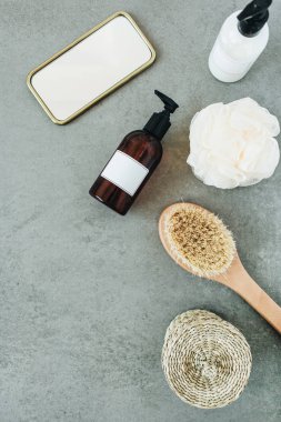 Banyo ürünleri: sıvı sabun, fırça, ayna, taş arka plan üzerinde sünger. Spa konsepti. Düz döşeme, üst görünüm.