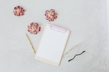 Pano maketi. Kuru şakayık, gözlük, kalem ile minimal ev ofis masası. Düz yatıyordu, üst görünüm blog kahraman başlığı.