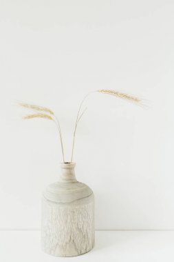 Beyaz arka planda tahta vazoda buket buketi var. Minimum çiçek bileşimi.