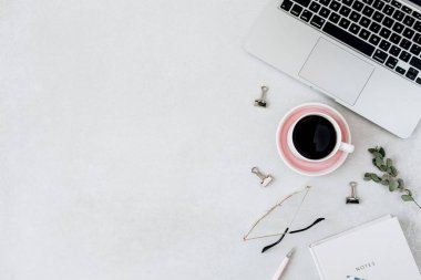 Minimalist ev ofis masası çalışma alanı. Dizüstü bilgisayar, kahve, bardak, dizüstü bilgisayar, boş arka plan da okaliptüs. Düz yatıyordu, üst tenli blog, web sitesi, sosyal medya kahraman başlık şablonu.