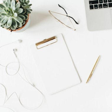 Boş kopya alan panosu, dizüstü bilgisayar, kulaklık, gözlük, beyaz arka plan üzerinde sulu ile Home ofis masası çalışma alanı. Düz yatıyordu, üst görünüm modern minimal kahraman başlığı.
