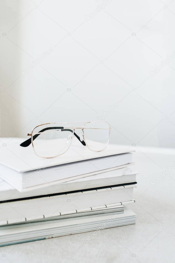 Glasses on books stack. Home office desk concept.