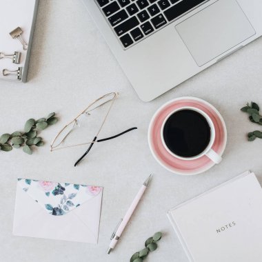 Dizüstü bilgisayar, kahve, dizüstü bilgisayar, okaliptüs, zarf ile minimal ev ofis masası çalışma alanı. Düz lay, üst görünüm sosyal medya arka plan.