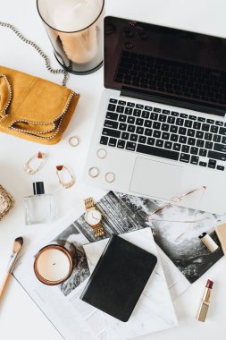 Dizüstü bilgisayar, parfüm, saat, ruj, fırça, beyaz arka plan aksesuarları ile Kadınsı modern ev ofis masası çalışma alanı. Düz yatıyordu, üstten bak. Moda blog, sosyal medya, web sitesi minimal kompozisyon. Kız patron kavramı.