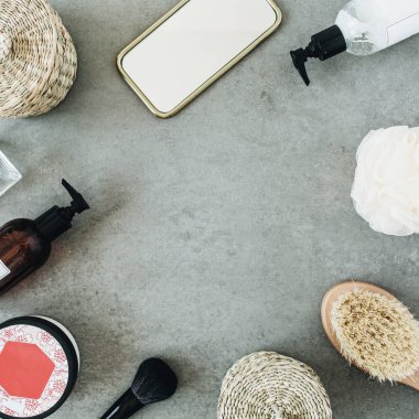 Yuvarlak çerçeve banyo ürünleri ile alay: sıvı sabun, fırça, ayna, taş arka plan üzerinde sünger. Spa konsepti. Düz döşeme, üst görünüm şablonu.