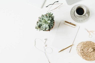 Boş maket panosu, kulaklık, kahve, beyaz arka plan üzerinde sulu ile home ofis masası çalışma alanı. Düz lay, üst görünüm modern minimal iş günlüğü şablonu.