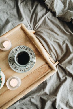 Sabah kahvaltısı kahveli yatakta. Düz yatıyordu, ahşap tepsi ve gri keten ile üst görünüm yaşam tarzı natürmort kompozisyon.