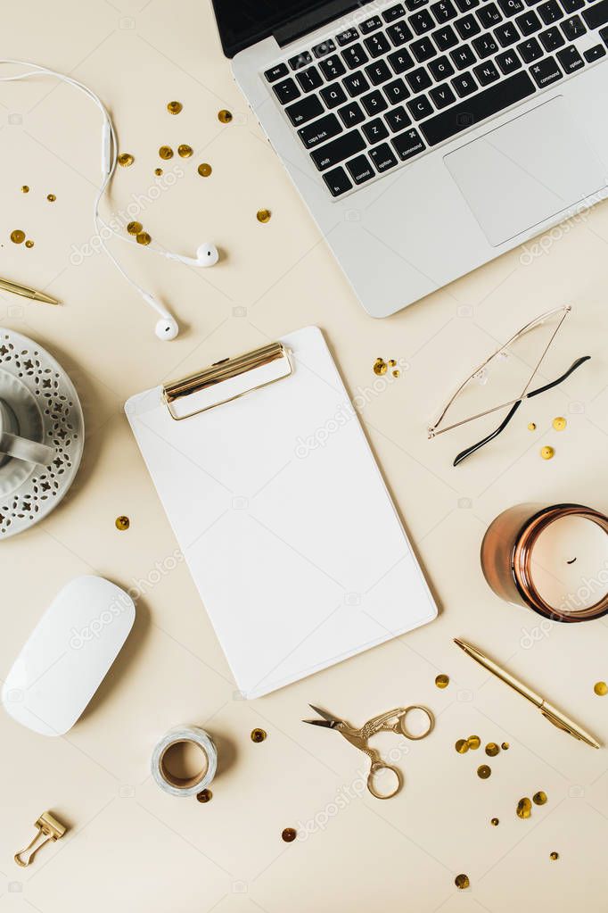 Round frame copy space mockup with clipboard, laptop, headphones, mouse, coffee, glasses on beige background. Home office desk workspace. Flat lay, top view minimal lifestyle blog template.