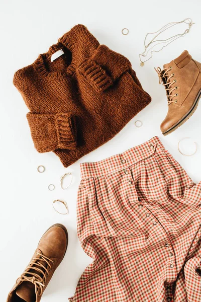 Kahverengi kazak, ayakkabı, etek, beyaz arka plan aksesuarları ile Moda rahat bir görünüm kompozisyon. Düz yatıyordu, üstten bak. Blog, sosyal medya, web sitesi minimal kolaj.