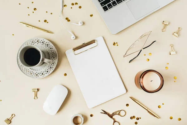 Round frame of home office desk workspace with laptop, blank copy space mock up clipboard, headphones, coffee, stationery on beige background. Flat lay, top view modern minimalist blog hero header template.