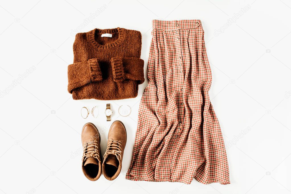 Fashion clothes look composition with brown sweater, shoes, skirt on white background. Flat lay, top view.
