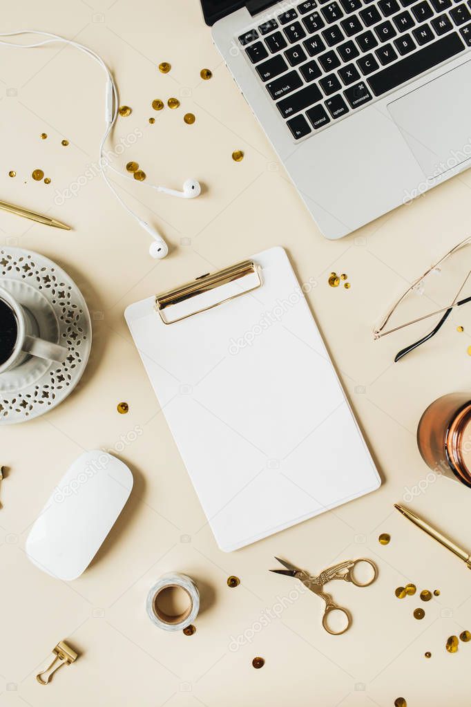 Round frame of home office desk workspace with laptop, blank copy space mock up clipboard, headphones, coffee, stationery on beige background. Flat lay, top view modern minimalist blog template.