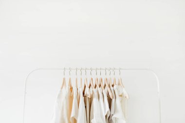 Minimal moda giysi kavramı. Beyaz arka planda askı üzerinde kadın bluzlar ve t-shirt. Moda blog, Web sitesi, sosyal medya kahraman başlık şablonu.