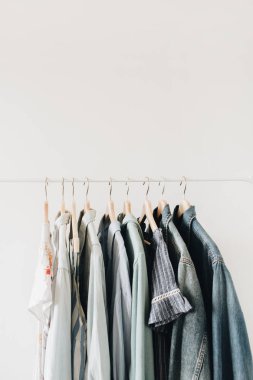 Minimal moda kavramı. Beyaz arka planda askı üzerinde kadın giyim.
