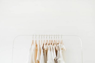 Minimal moda giysi kavramı. Beyaz arka planda askı üzerinde kadın bluzlar ve t-shirt. Moda blog, Web sitesi, sosyal medya kahraman başlık şablonu.