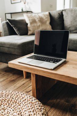 Masif ahşap masada boş mockup ekranı ile laptop. Modern minimal Iskandinav Nordic iç tasarım konsepti. 