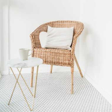 Mozaik zeminli balkonda yastık ve mermer sehpa ile Rattan Sandalye. Minimal modern parlak Iskandinav Nordic iç tasarım konsepti.