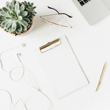 Boş kopya alan panosu, dizüstü bilgisayar, kulaklık, gözlük, beyaz arka plan üzerinde sulu ile Home ofis masası çalışma alanı. Düz yatıyordu, üst görünüm modern minimalist blog konsepti.