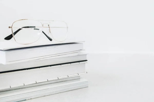 Glasses on books stack. Minimalist business hero header background.