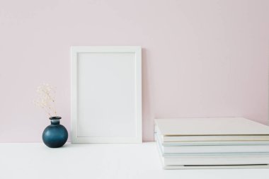 Front view of mock up photo frame with blank space for text on pink background. Minimalist home office desk. Blog hero header.