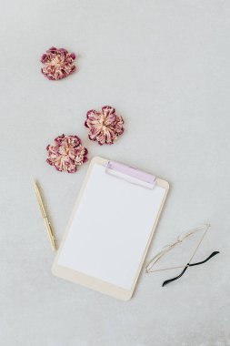 Pano maketi. Kuru şakayık, gözlük, kalem ile minimal ev ofis masası. Düz lay, üst görünüm blog şablonu.