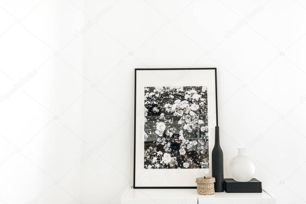 Photo frame on chest of drawers with decoration at white wall. Minimal modern Scandinavian nordic interior design concept.