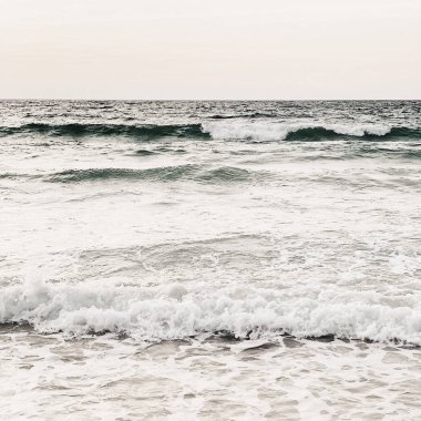 Beyaz kum, dalgalar ve Phuket, Tayland açık gökyüzü ile bej deniz ile güzel tropikal plaj manzarası. Nötr renklerle minimal kompozisyon. Yaz ve seyahat konsepti.