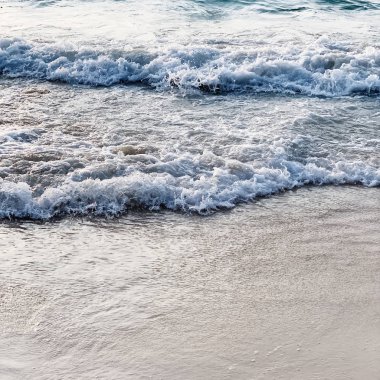 Phuket, Tayland dalgalar ile beyaz kum ve mavi deniz ile güzel tropikal plaj manzarası. Nötr renklerle minimal kompozisyon. Yaz ve seyahat konsepti.