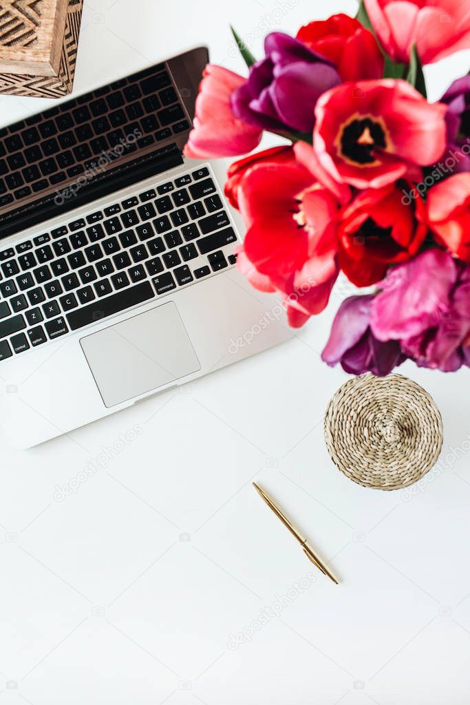 Home office workspace background with laptop, tulip flowers bouquet. Flat lay, top view lady boss business composition.