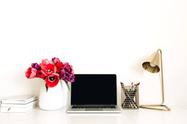 Dizüstü bilgisayar, lale çiçekleri buket, kırtasiye, lamba ile Ev ofis çalışma alanı arka plan. Kopya alanı şablonu ile Minimalist bayan patron blog kahraman başlık. Yaşam tarzı natürmort kavramı.