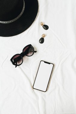Düz yatıyordu, kopya alan telefon şablonu ile üst görünüm minimal kadın moda yaşam tarzı kolaj, şapka, güneş gözlüğü, beyaz keten küpe. Bayan patron güzellik blog arka plan.