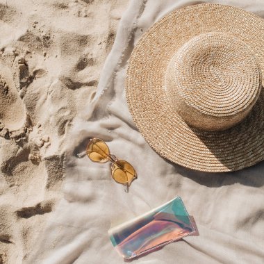 Beyaz kum, ayak adımları, hasır şapka, güneş gözlüğü ve durumda ile nötr battaniye ile Tropikal güzel plaj. Rahatlatıcı bir atmosfer. Yaz seyahati veya tatil konsepti. Minimalist arka plan.